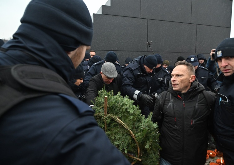 Prowokatorzy składający kontrowersyjny wieniec pod pomnikiem ofiar katastrofy smoleńskiej Prowokatorzy zakłócili miesięcznicę smoleńską. Doszło do przepychanek