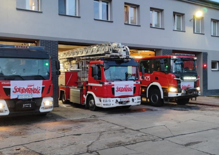 Pojazdy straży pożarnej z flagami NSZZ 