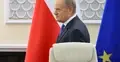 Premier Donald Tusk, w tle flaga Polski i UE
