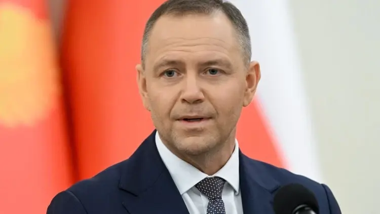 Karol Nawrocki na tle flagi
