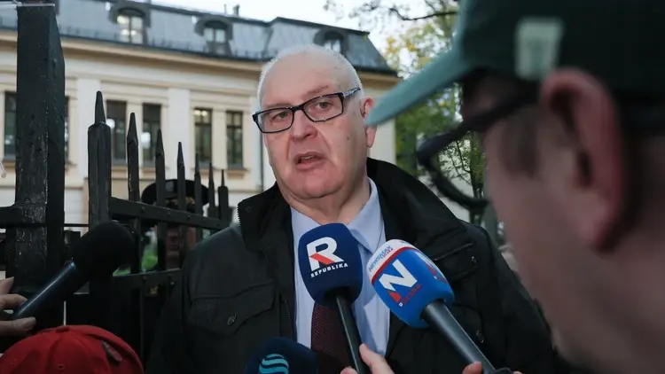 Bogdan Święczkowski odpowiada na pytania dziennikarzy. W tle Trybunał Konstytucyjny