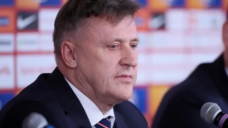 Prezes PZPN Cezary Kulesza na konferencji prasowej, w tle loga firm