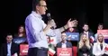 Mateusz Morawiecki przemawia do mikrofonu, w tle ludzie