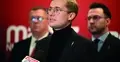 Marcin Osowski, mikrofon, dwie postaci w tle