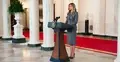 Melania Trump przemawia, w tle kolumny i czerwony dywan
