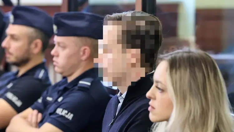 Sebastian M. na sali sądowej. W tle policjanci i kobieta