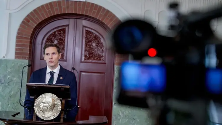 Jorgen Watne Frydnes przemawia do mikrofonu, kamera w tle