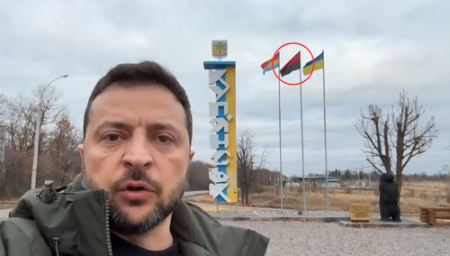 Prezydent Ukrainy Wołodymyr Zełenski na tle banderowskiej flagi