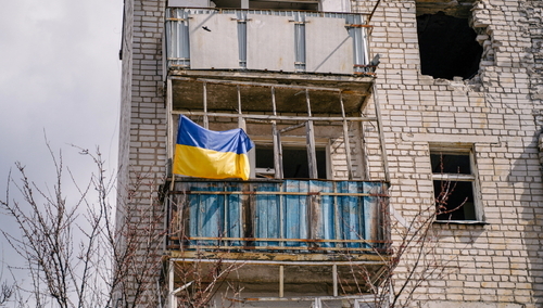 Ukraińska flaga na zniszczonym budynku w Izium