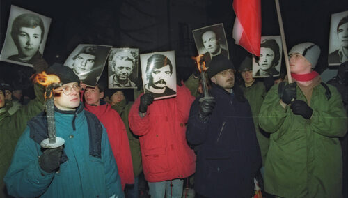 Protest ludzi, trzymających czarno-białe zdjęcia