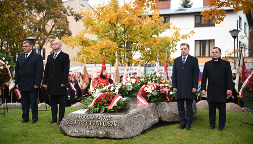 Piotr Duda, Grzegorz Adamowicz, Bartłomiej Mickiewicz i Maciej Kłosiński przy grobie ks. Jerzego Popiełuszki