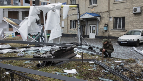 Kijów. Mężczyzna patrzy na zniszczenia po wkroczeniu wojsk rosyjskich na Ukrainę