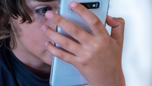 Dziecko grające na telefonie, zdjęcie ilustracyjne