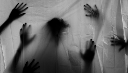 Ręce i twarz za prześcieradłem