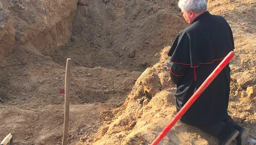 Wielki Piątek 2022. Kard. Krajewski modli się nad masowym grobem w Borodziance