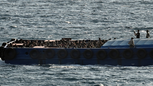 Łódź motorowa z uchodźcami i migrantami w porcie Lavrio w Grecji