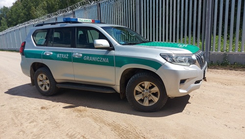 Samochód Straży Granicznej przy barierze na granicy z Białorusią