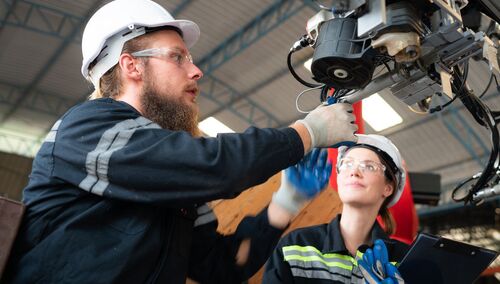 Inżynier instalujący system elektrycznego ramienia robota