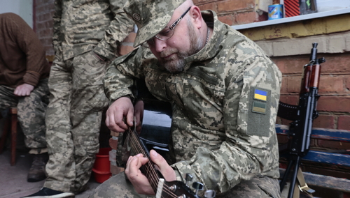 Ukraiński żołnierz gra na gitarze
