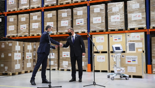 Prezydent RP Andrzej Duda (C) i minister ochrony zdrowia Ukrainy Wiktor Laszko (L) podczas uroczystości przekazania przez Polskę pomocy solidarnościowej dla Ukrainy w centrum logistycznym Biokon w Kijowie.