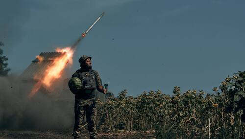 Ukraiński żołnierz na tle systemu rakietowego Grad