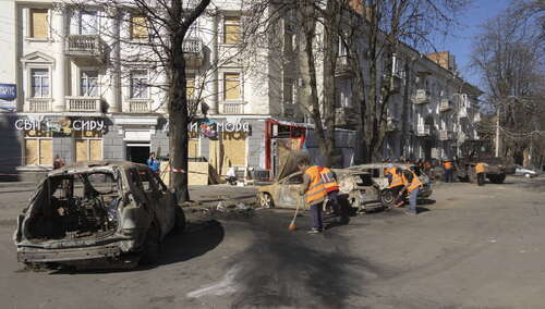 Ukraińcy czyszczący ulicę po rosyjskim ataku na Sumy