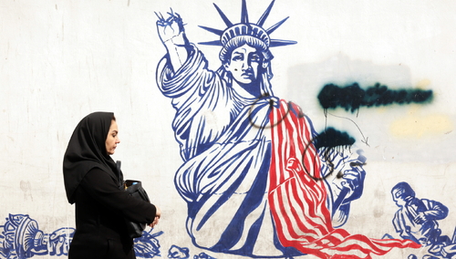 Irańska kobieta na tle antyamerykańskiego murala. Ilustracja poglądowa