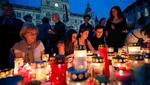 Ludzie zapalają świece w hołdzie zabitym w Grazu. 
