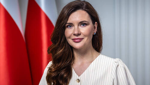 Kobieta w białym ubraniu z polską flagą w tle