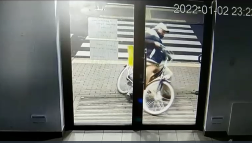 mężczyzna taranujący rowerem drzwi do urzędu