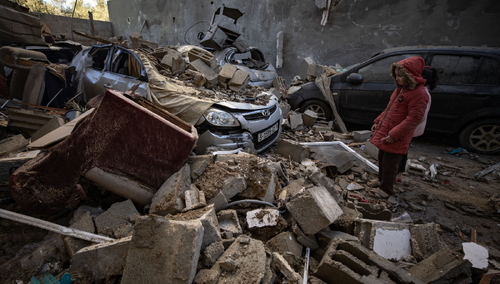 Palestyńskie dzieci patrzą na gruzy w pobliżu ich domu po nocnych izraelskich nalotach na obóz dla uchodźców w Rafah w południowej Strefie Gazy