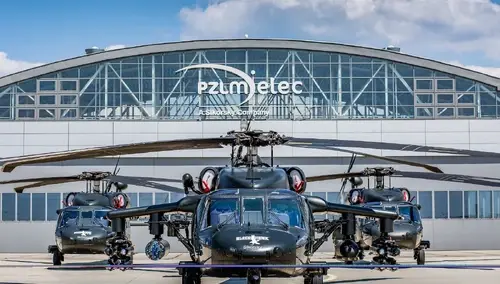 śmigłowce stojące przed hangarem