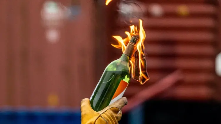 osoba trzymająca w ręce koktajl Mołotowa