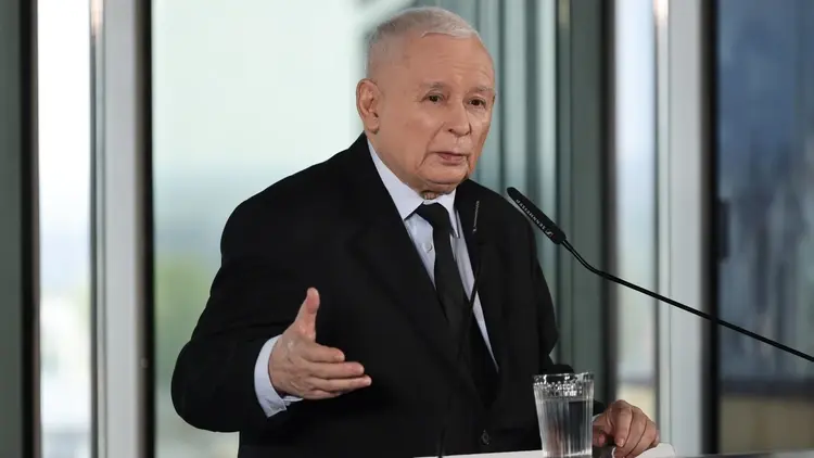 Jarosław Kaczyński przemawia do mikrofonu i gestykuluje