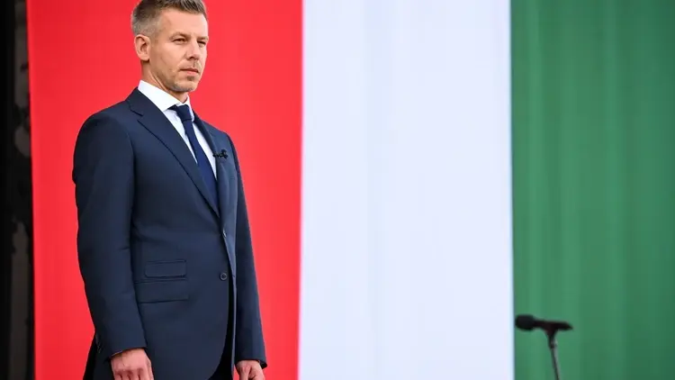 Peter Magyar stoi na tle węgierskiej flagi