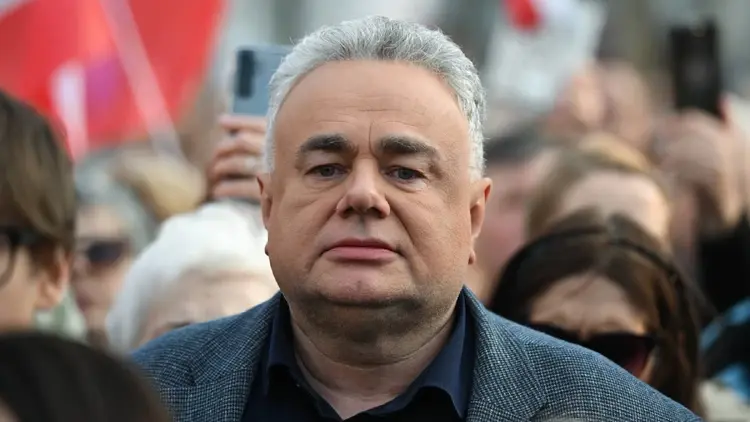 Tomasz Sakiewicz na manifestacji, w tle ludzie i biało-czerwone flagi