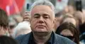 Tomasz Sakiewicz na manifestacji, w tle ludzie i biało-czerwone flagi