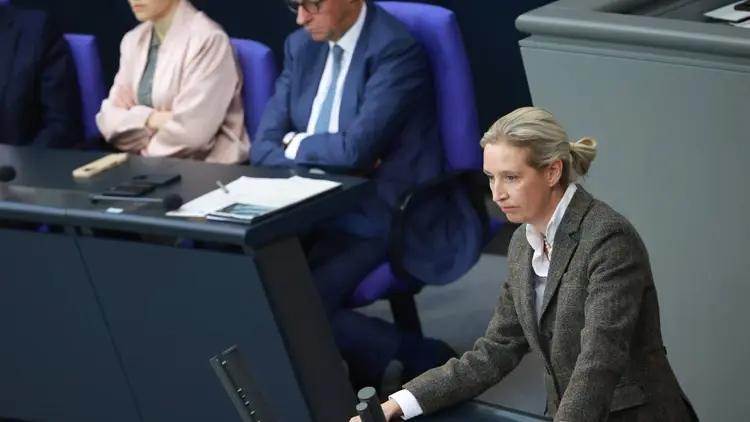 Alice Weidel przemawia w Bundestagu. W tle kanclerz Niemiec Friedrich Merz