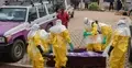 pracownicy sanitarni przy odkażaniu trumny z ciałem ofiary wirusa ebola w buni w kongo