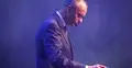 Friedrich Merz sięgający po szklankę z wodą