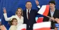 Karol Nawrocki wraz z rodziną podczas wieczoru wyborczego po ogłoszeniu wyników wyborów prezydenckich. W tle polskie flagi i zgromadzeni zwolennicy.