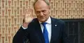 Donald Tusk z uniesioną dłonią do góry