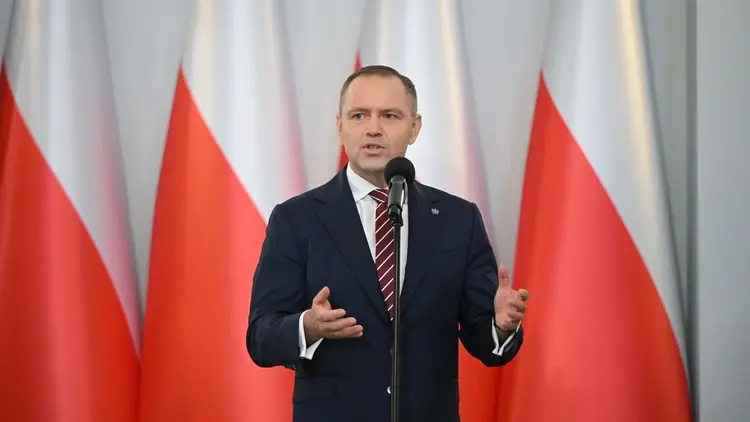 Karol Nawrocki przemawia na tle biało-czerwonych flag