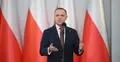 Karol Nawrocki przemawia na tle biało-czerwonych flag