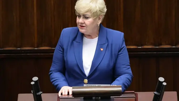 Małgorzata Pępek ubrana w niebieską marynarkę przemawia w mównicy sejmowej