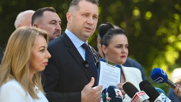 Przemysław Czarnek przemawia do mikrofonu, w ręku trzyma dokumenty