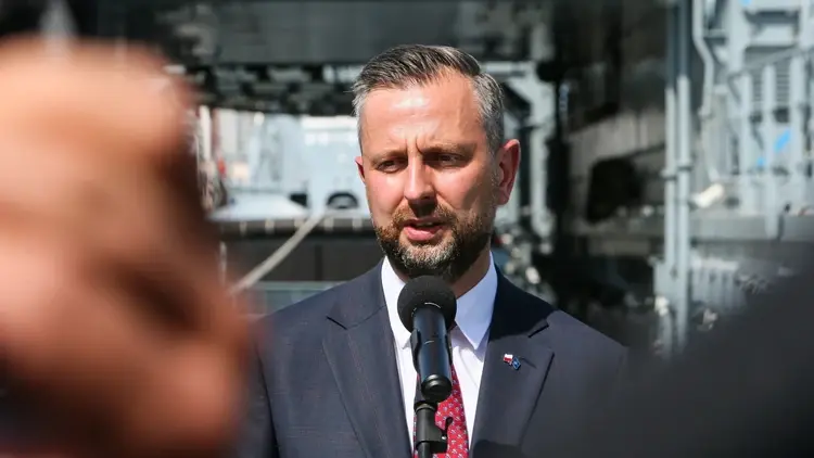 Władysław Kosiniak-Kamysz przemawia do mikrofonu. W tle Morski Port Wojenny w Świnoujściu