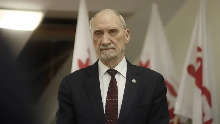 Antoni Macierewicz na tle flag