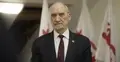 Antoni Macierewicz na tle flag