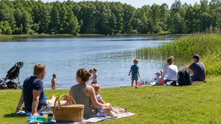 Rodziny wypoczywające nad jeziorem - grafika poglądowa